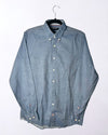 Blue button-up shirt on a hanger against a white background